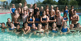 Swim Team group posing for picture inside swimming pool