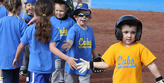 youth baseball players giving eachother good game high fives.