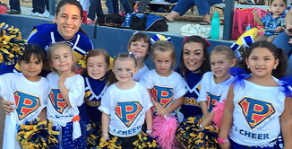 Picture of smiling young girls with High School cheerleader at the cheer camp performance. 